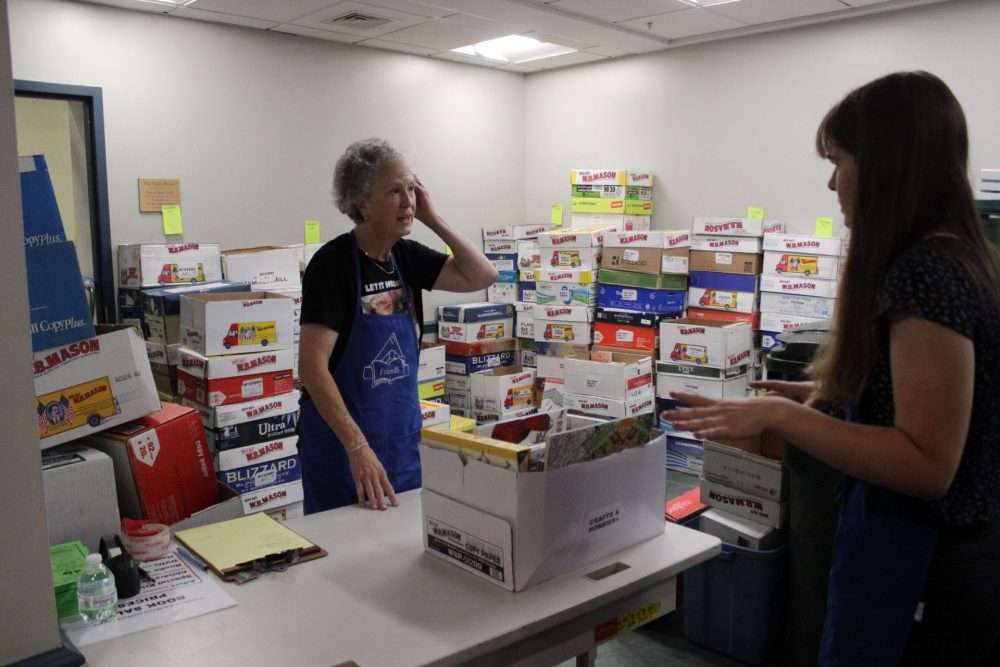 Terri Evans, left, helps a volunteer during the Friends of the Morse Institute Library’s Book andBake Sale on Sept. 27. The storage area next to the Lebowitz Meeting Hall is named for her and her husband, Bruce.
