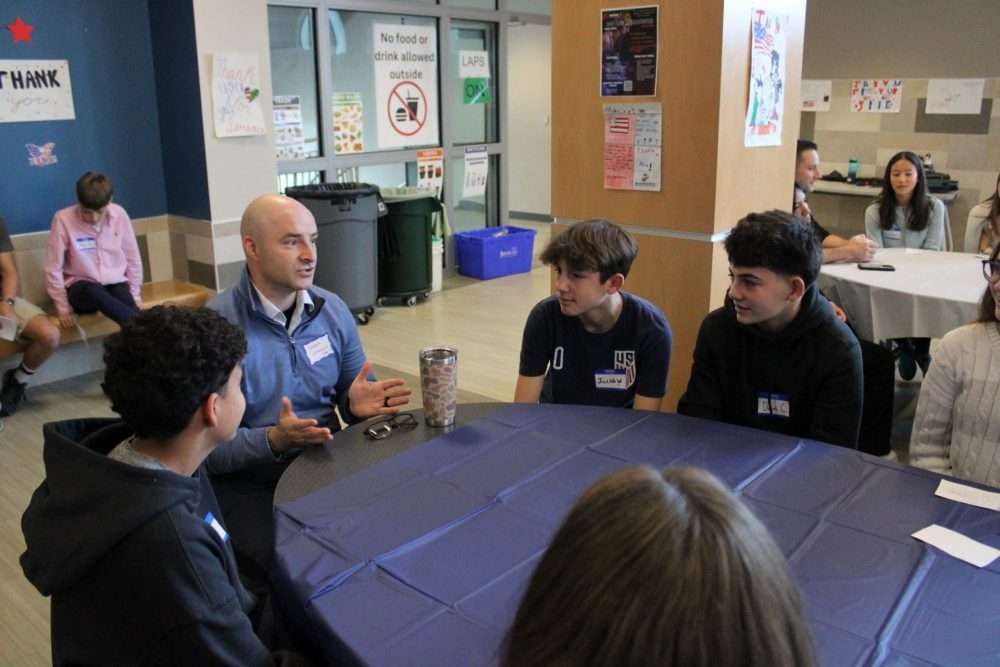 Veteran Joseph Lavesque chats with eighth-graders at Kennedy Middle School during the annualVeterans Breakfast on Nov. 7.