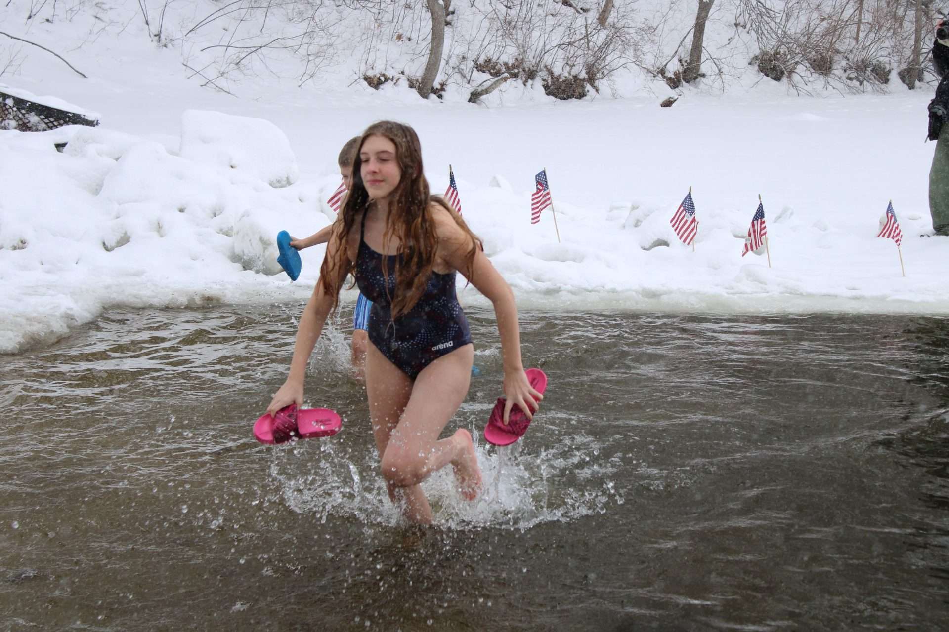 Rain Burnham, front, and her brother, River, emerge from Lake Cochituate during the annualPassion Plunge at AMVETS Post 79 on Feb. 7.