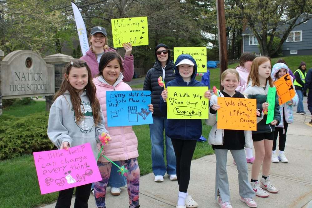 Members of Girl Scout Troop 64073 held signs and cheered on participants at the beginning ofthe annual Walk to End Homelessness on May 3 at Natick High School.