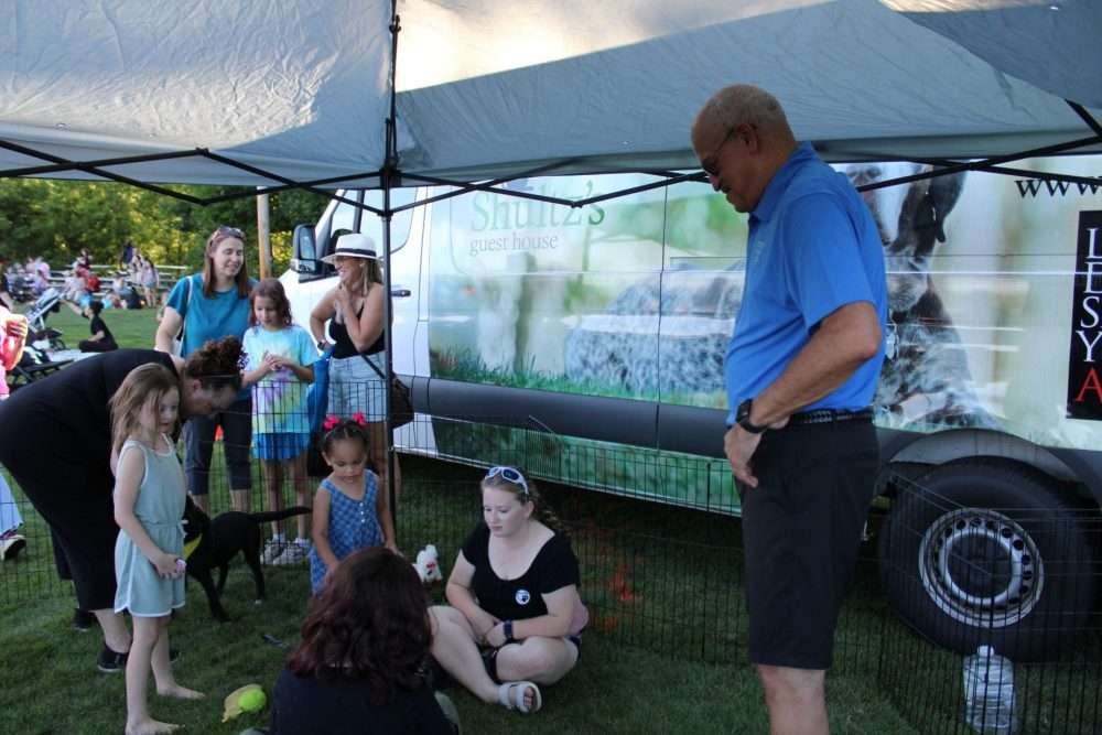 Police Chief James Hicks, right, checks out some puppies from Shultz’s Guest House ready foradoption during the annual National Night Out at Memorial Field on Aug. 4.