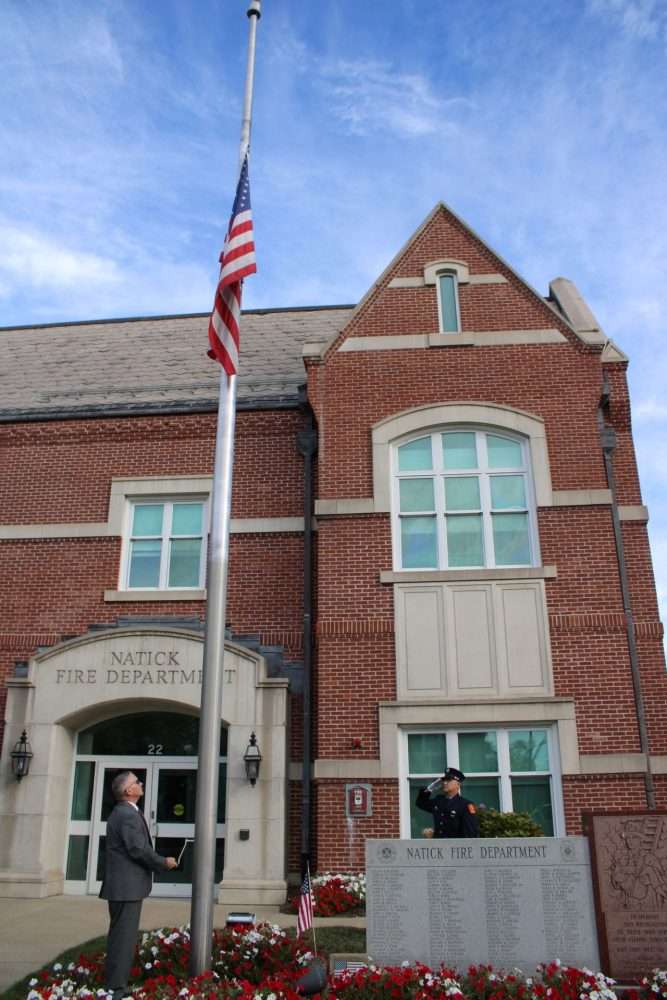 John Martin, left, the town’s Veterans Services officer, takes part in the flag ceremony in frontof the fire station during observances marking the 25 th anniversary of the terrorist attacks on Sept. 11, 2001.