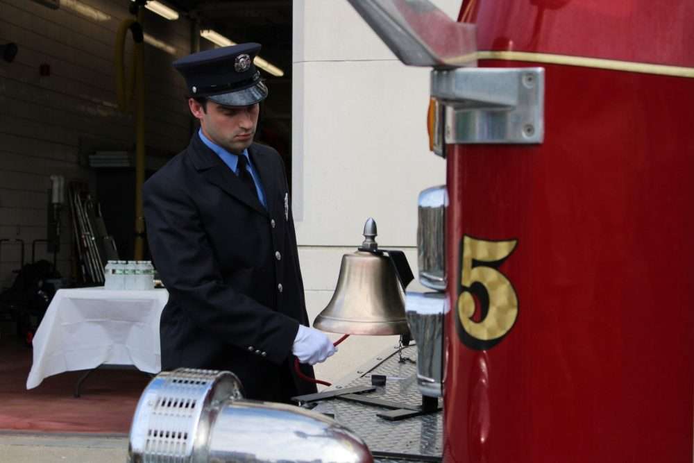 Jacob Opela, a member of the Natick Fire Department, rings the bell in honor of those whoperished during the terrorist attacks on Sept. 11, 2001.